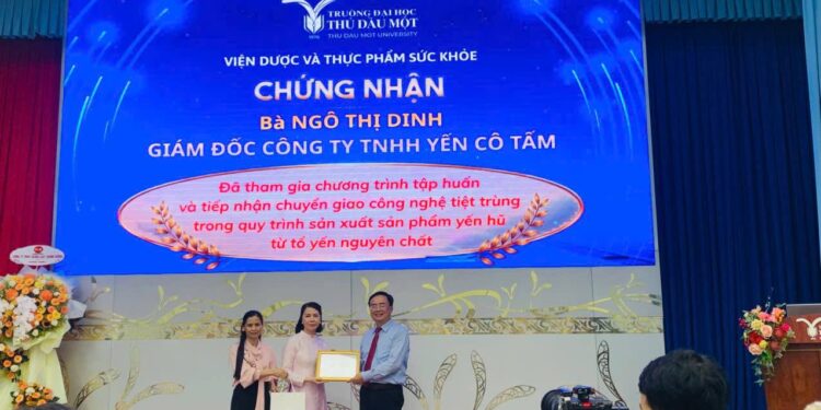 Đại diện Viện Dược và Thực phẩm sức khỏe thuộc Trường Đại học Thủ Dầu Một trao chứng nhận chuyển giao quy trình công nghệ tiệt trùng Retort cho Công ty TNHH Yến Cô Tấm